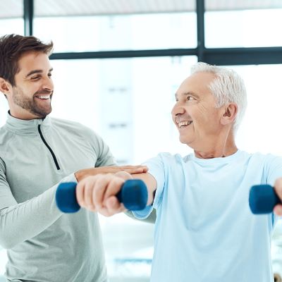 Trainer helping person lifting weights