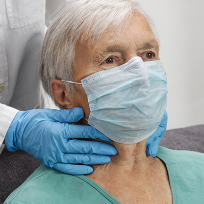 Elderly woman getting her thyroid checked at the doctor